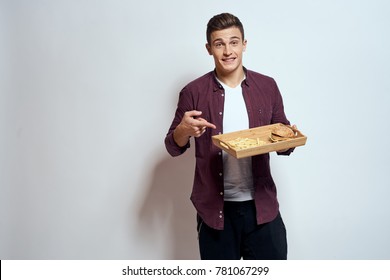 man with a tray of fast food on a light background, a hamburger, french fries, burger, potato,  cheeseburger                               