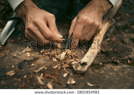 A man tries to make a fire with an angle