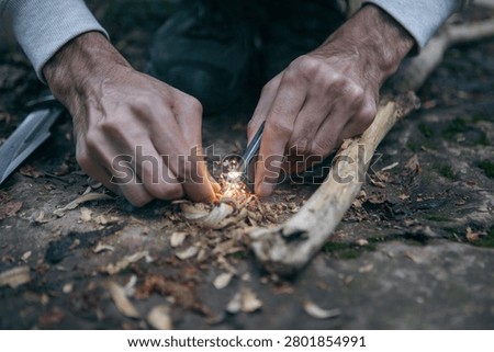 A man tries to make a fire with an angle