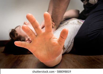 Man tries to strangle woman on the floor - domestic violence concept