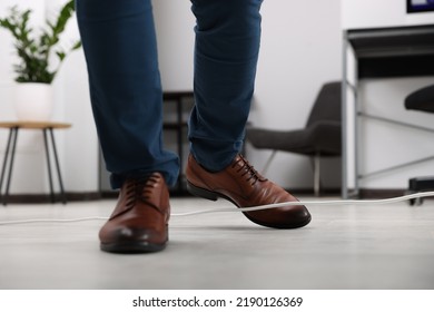 Man Tripping Over Cord In Office, Closeup