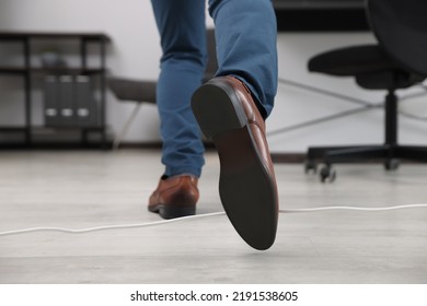 Man Tripping Over Cord In Office, Closeup