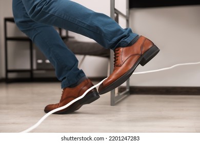 Man Tripping Over Cord In Office, Closeup