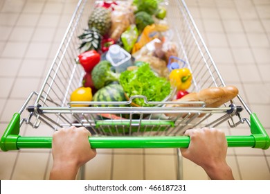 Man with trolley full of products in supermarket top view