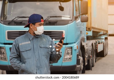 Man Truck Driver Transport Wearing A Medical Mask Finds A Location On His Smartphone Digital Icon Display. Background Semi-truck Container Delivery Warehouse