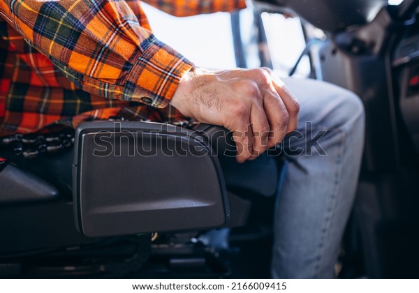 Man trucker\
driving in a cabin of his\
truck