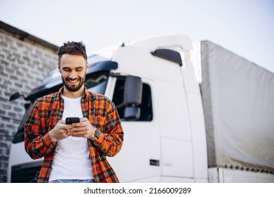 Man trucker talking on the phone by his white truck - Shutterstock ID 2166009289