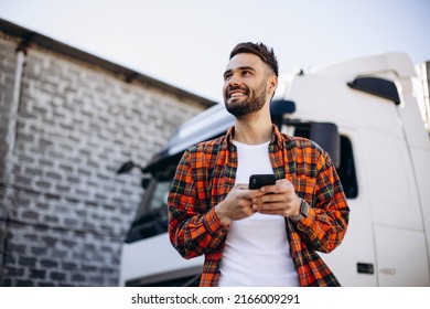 Man trucker talking on the phone by his white truck - Shutterstock ID 2166009291