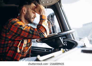 Man trucker tired driving in a cabin of his truck - Shutterstock ID 2166009431