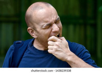 man trying to crack a nut with his teeth. difficult problem concept