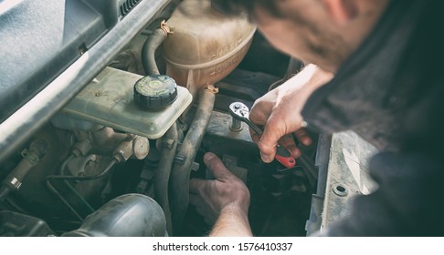 The Man Is Trying To Fix The Broken Old Car At Home