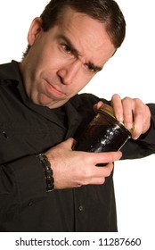 Man Trying Hard To Open The Lid On A Jar Of Canned Food