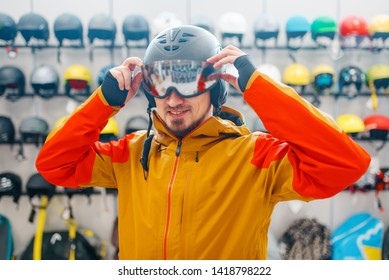Man trying on helmet for ski or snowboarding