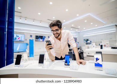 Man Trying Out New Smart Phone. Tech Store Interior.