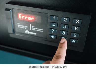 Man trying to press passwords on safety lock pad for open a safety box and wrong a PIN code, alarm red light warning error