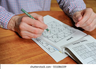 Man is trying to solve a sudoku with a pencil
