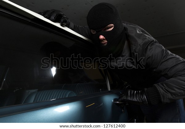 man trying to steal blue\
car