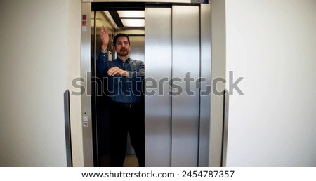 Man Trying To Stop Door In Elevator