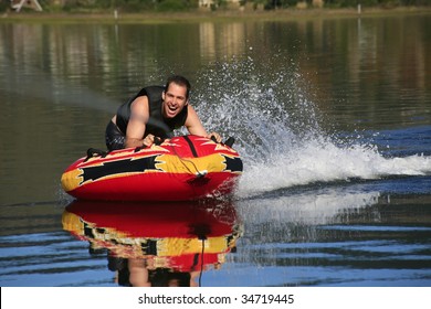 Man Tubing Behind A Boat