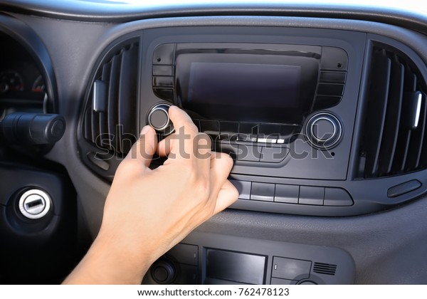 Man tuning car radio,\
closeup