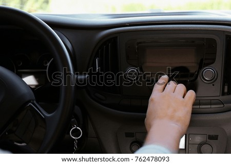 Man tuning radio in car