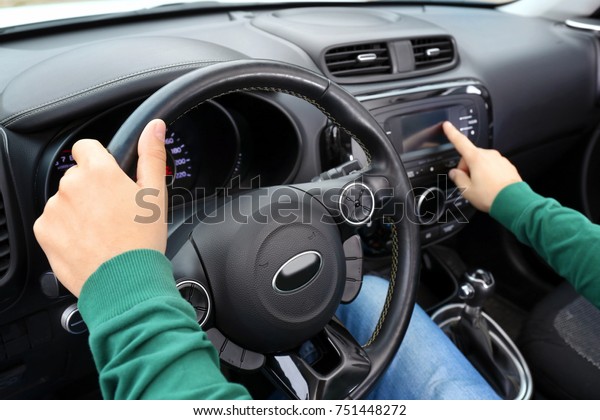 Man tuning radio in\
car