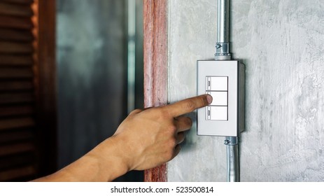 Man Turning On Or Off On A Light Switch.