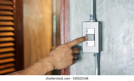 Man Turning On Or Off On A Light Switch.