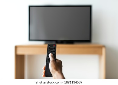 Man turning on smart TV with remote control