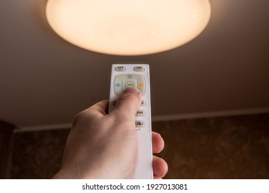 The Man Turns On The Led Lamp With The Control Panel. Led Ceiling Light In The House. Smart House