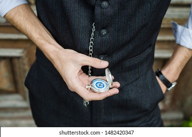 Man in twenties look with watch and silver chain. White shirt with waistcoat.