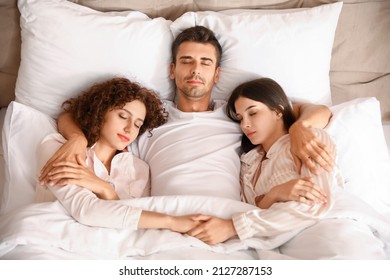 Man With Two Beautiful Women In Bed. Polyamory Concept