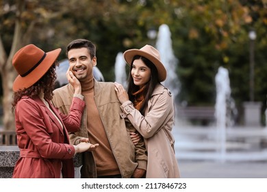 Man With Two Beautiful Women In Park. Polyamory Concept