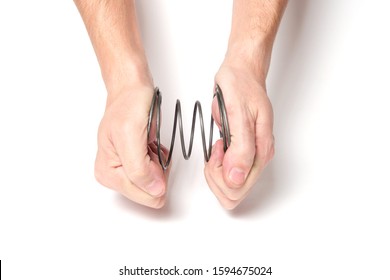 Man with two hands squeezes a spring on a white background - Shutterstock ID 1594675024