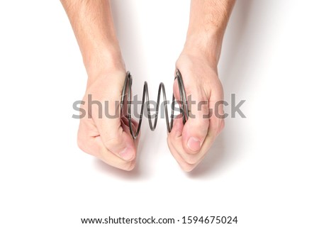 Man with two hands squeezes a spring on a white background