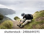 Man tying boot laces. Omanawanui track in the Waitakere Ranges. Auckland.