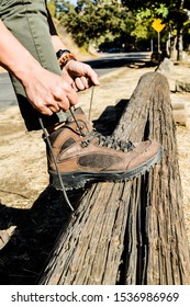 Man Tying Hiking Shoes On Wooden Log.