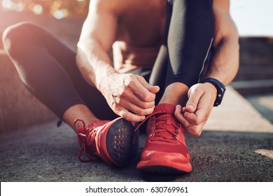 Man tying jogging shoes.A person running outdoors on a sunny day.