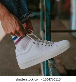 Man Tying Laces On A White Sneaker