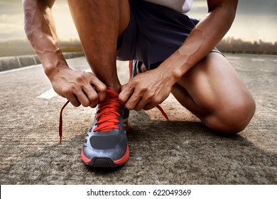 Man tying running shoes - Shutterstock ID 622049369