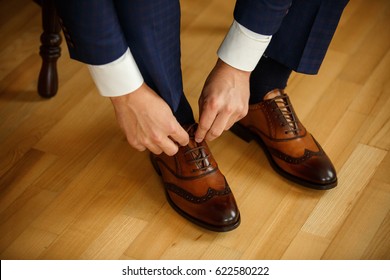 Man tying shoes laces on the wooden floor	 - Powered by Shutterstock