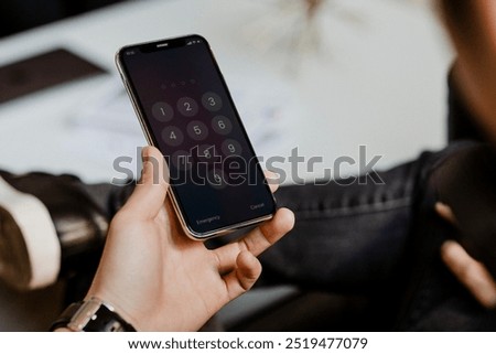 Man typing his phone passcode. Man with smartphone. Photo of business man using mobile phone, digital device gadget. Closeup of man holding mobile phone, showing smartphone screen passcode