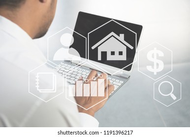 Man typing the laptop to find the home with property value diagram icon for real estate concept - Shutterstock ID 1191396217
