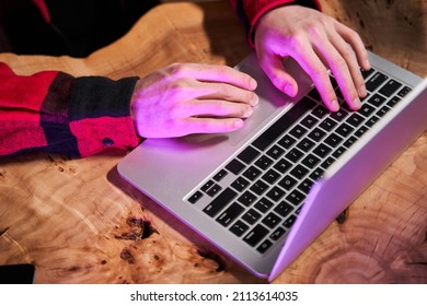 Man typing at the laptop keyboard while sitting at the prohibited social networks or sites