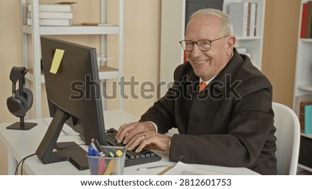 Man typing on keyboard with hands on keys, smiling at monitor in building; contentment productivity focus.