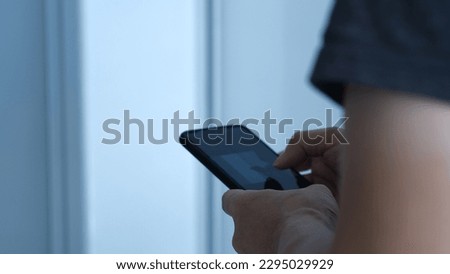 a man is typing on a smartphone secretly in the corner 商業照片 © 