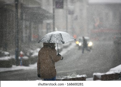 Man With Umbrella During Snow Storm In The Street