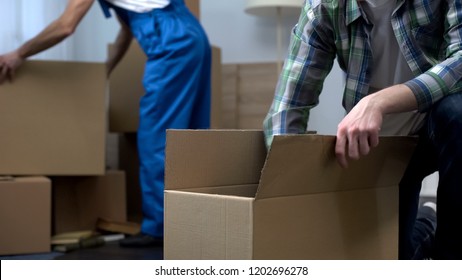 Man Unboxing Things In New Apartment, Moving Company Worker Bringing Boxes