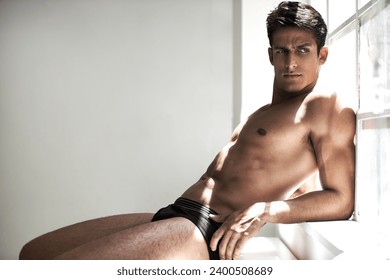 Man, underwear and window with body, healthy or thinking with vision, fitness or remember in home. Guy, person and briefs with ideas, memory or choice for strong muscle, abdomen or wellness in house - Powered by Shutterstock