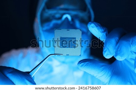 Man in uniform holds microprocessor with forceps. Repair microprocessor electronics electrical equipment. Dust protection at enterprise for creation electronic devices. Chemical elements in design